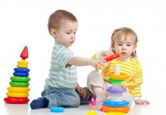 2 børn stabler plastikringe oven på hinanden