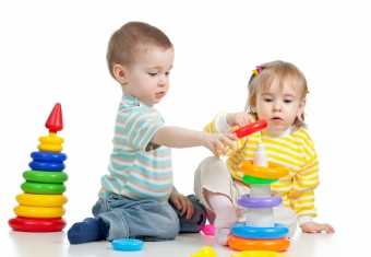 2 børn stabler plastikringe oven på hinanden